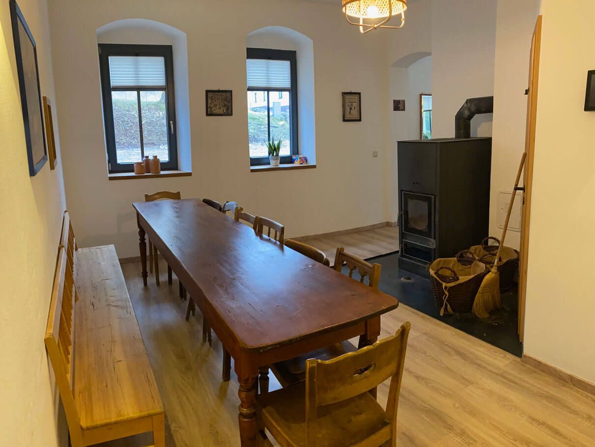 FASA-Lodge Innenaufnahme mit langem Holztisch und Ofen